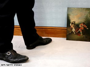 A Christie's employee stands beside a painting  at Christie's auction house in London on July 4.