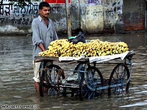 A banana vendor stands on a flooded street as he waits for customers in Amritsar, India, on August 13.