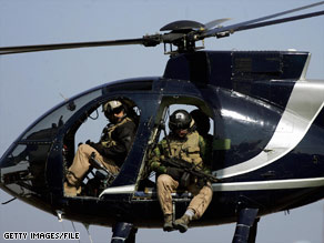 Members of the U.S-based Blackwater security firm scan Baghdad from a helicopter in 2005.