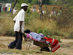 A man from Zimbabwe wheels his sick relative to a cholera clinic.