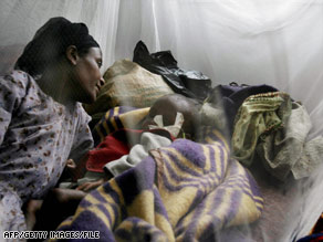 A woman lies next to her sick child at a medical center in Sheshemene, Ethiopia, in July.