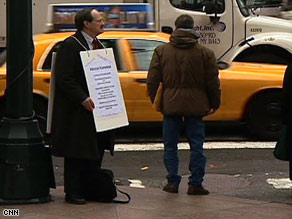 Paul Nawracki, jobless since February, stands on New York corners with a sign announcing his job search.