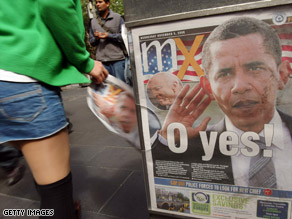 A member of the public picks up a copy of a newspaper with U.S. President-elect Barack Obama on the cover in Sydney, Australia