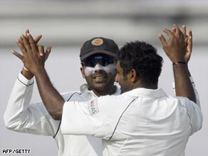 Sri Lanka heroes Jayawardene and Muralitharan (right) celebrate a wicket for the spinner.