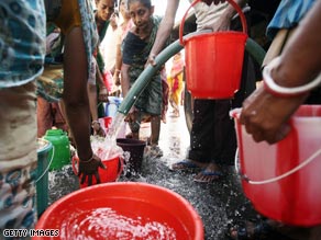 People in India, where millions don't have access to clean drinking water,  fill buckets from a supply pipeline.