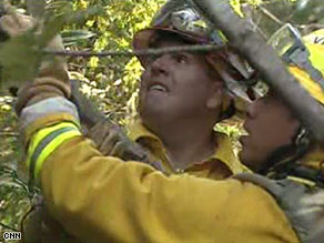 National Guardsman Mike Valdivia, right, cuts through the thick brush to help battle wildfires in California.