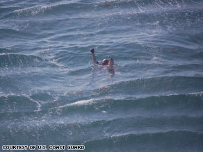 A U.S. Coast Guard rescue swimmer gives a thumbs up after reaching Chris Marino.