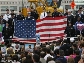 Memorial service participants Thursday hold a flag rescued from the World Trade Center disaster.