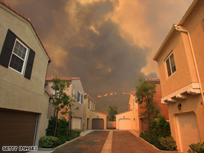 A U.S. Forest Service firefighter battles flames in the Angeles National Forest on Sunday.