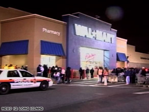 A woman sits outside the Toys "R" Us after Friday morning's shooting.