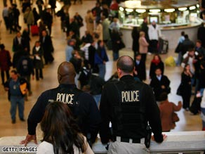 Police watch over travelers at New York's Grand Central Terminal before Thanksgiving.