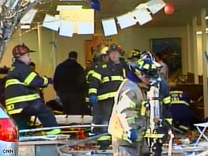 Rescue workers at the scene after a car plowed into a storefront where a Hannukah celebration was taking place.