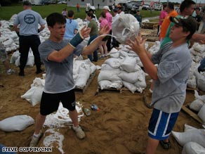 April Dzubic, right, facing forward, of St. Louis, Missouri, passes a sandbag in Winfield on Friday.