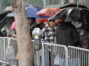 A woman makes her way in through the pouring rain in downtown Los Angeles, California, on Wednesday.