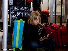 Mia Watson, 7, reads a book while she waits Monday at the Seattle-Tacoma International Airport.