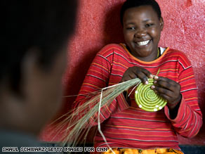A woman makes the base of a basket at a workshop where Hutus and Tutsis work together.