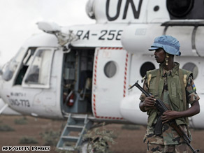 A Rwandan soldier serving with the U.N.-African Union peacekeeping force in Darfur guards a U.N. helicopter.