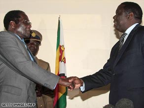 Mugabe (left) and Tsvangirai last week at the ceremony that paved the way for power-sharing talks.