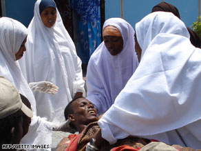 A man picks through debris following Tuesday's mortar attack in Mogadishu, where fighting continues.