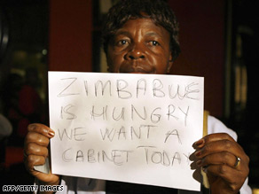A women holds a sign inside a Harare hotel where power-sharing talks took place Thursday.