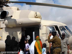 Families rescued from the floods get into an army helicopter in Hadrmout province.