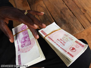 A money-changer in Mozambique holds Zimbabwean $10 million and $50 million bills in May.