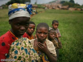 People carry their belongings as they flee fighting, near Kibumba, some 25 miles north of Goma.