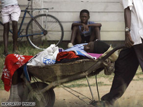 A man carries a relative in a wheelbarrow to a cholera clinic in Harare on Tuesday.