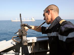 A French soldier cleans a weapon as the frigate Nivose escorts shipping off the coast of the Djibouti.