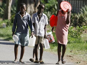 Zimbabweans stand in line for water Monday in Harare, where a cholera outbreak has struck hundreds of people.