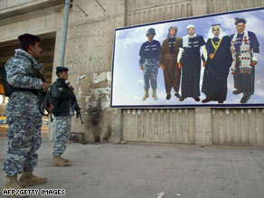 Iraqi soldiers on Monday look at a poster in Kirkuk depicting the region's various ethnic groups.