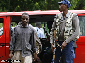 A suspected activist is led into court in Harare by police on December 24.