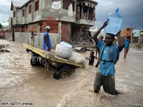 A man carries drinking water through the flooded streets of Gonaives, Haiti, last month.