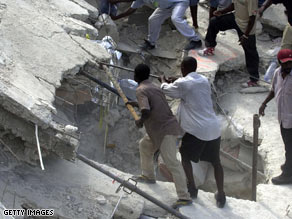 Volunteers search for survivors in the rubble of a school that collapsed Friday in Petionville.