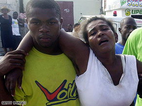A woman anguishes over her missing child Monday near where a school collapsed in Haiti.