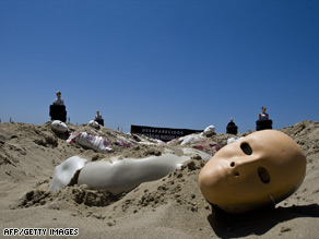 Dummies represent victims of violence in a protest Tuesday on Copacabana beach in Rio de Janeiro.