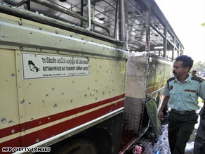 Sri Lankan security officials inspect the bus that was the target of the roadside bomb attack.