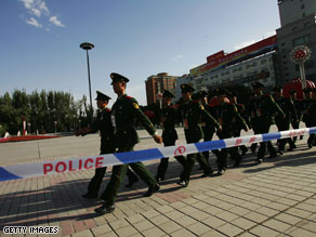 Residents looks on during the Beijing Olympic torch relay Tuesday in Urumqi, Xinjiang.