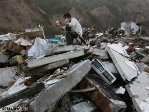 A rescuer looks at a photo pulled from the debris following the quake in China.