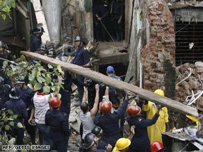 Rescue workers clear away debris after a building collapsed Wednesday in Mumbai, India.