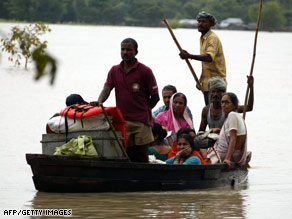 Indian villagers use a boat to travel through floodwaters in the Araria district northeast of Patna on Wednesday.