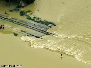 People walk along a flooded railway track in Madhepura, India.