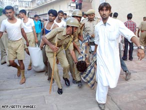 Victims of the stampede near an Indian Hindu temple are carried away from the scene.