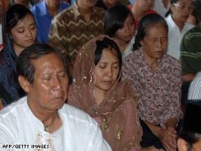 Australian relatives of Bali bombing victims hug Sunday in front of the monument to the bombings.