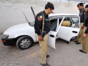 Pakistani policemen inspect a bullet-riddled car of a kidnapped Iranian diplomat on Thursday.