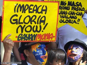 Protesters display slogans in front of the House of Representatives in Manila on Tuesday.