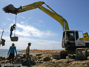 Laborers work on a construction site in a fishing village in Indonesia's Aceh on December 21.