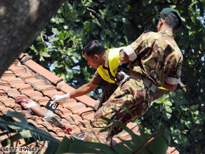 Sri Lankan police officers investigate Sunday's suicide bombing near Colombo.