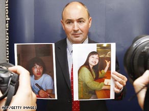 Detective Superintendent Steve Wade of Northumbria Police holds up photographs of Chinese students Zhen Xing Yang, left and Xi Zhou .
