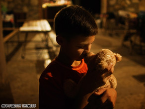 Laskha Beruashvili, 9, kisses his stuffed bear at a Red Cross facility in the Georgian village of Tzheta.